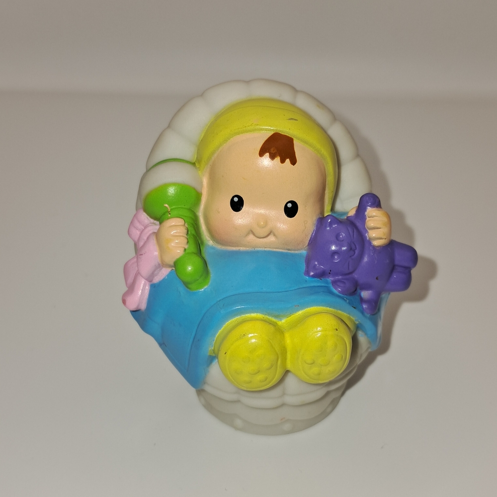 Fisher-Price Little People baby figure sitting in a white cradle